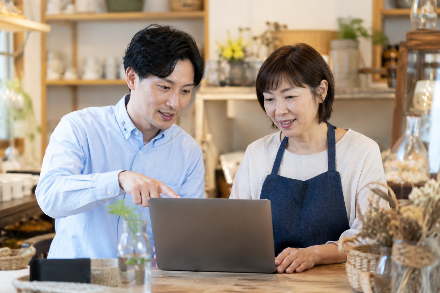 店主とコンサルがノートPCを見ながら相談している様子